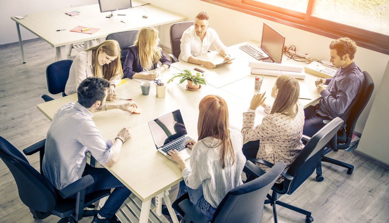 business meeting with 8 people sitting at a conference table