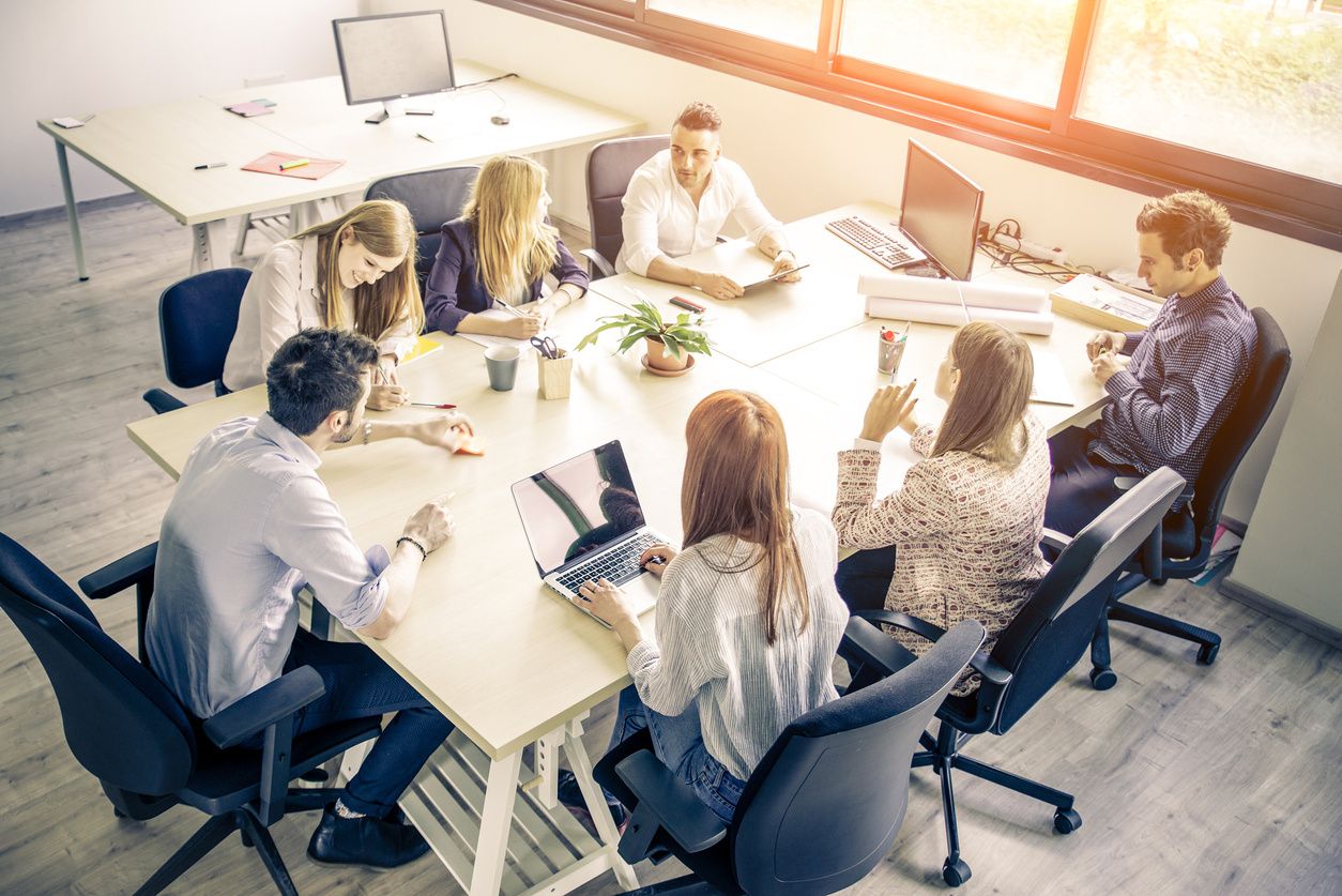 business meeting with 8 people sitting at a conference table